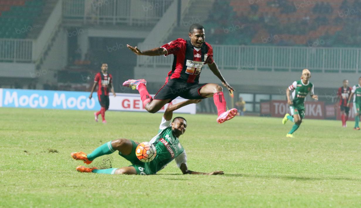 Pemain Persipura Jayapura, Tinus Pae melompat menghindari sapuan pemain PS TNI, Ganjar pada laga Torabika SC 2016 di Stadion Pakansari, Bogor, Minggu (19/6/2016). (Bola.com/Nicklas Hanoatubun)