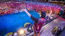 Orang-orang menonton pertunjukan musik sambil bermain air di sebuah taman air atau water park di Wuhan, provinsi Hubei, China pada 15 Agustus 2020. Taman air itu dibuka lagi pada Juni setelah Wuhan mengurangi peraturan ketat karantina yang sudah berjalan selama 76 hari. (STR/AFP)