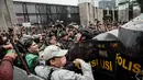 Pengunjuk rasa berusaha bertahan dan melawan dengan melempar botol air plastik. (YASUYOSHI CHIBA/AFP)