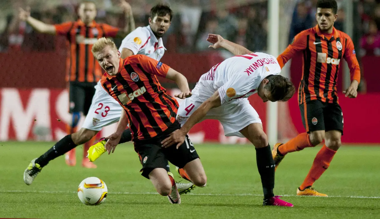 Pemain Shakhtar Donetsk, Viktor Kovalenko (kiri)  terjatuh saat berebut bola dengan pemain Sevilla, Grzegorz Krychowiak dpada leg kedua semifinal Liga Europa di Stadion Ramon Sanchez Pizjuan, Sevilla, Jumat (6/5/2016) dini hari WIB. (AFP/Jorge Guerrero)