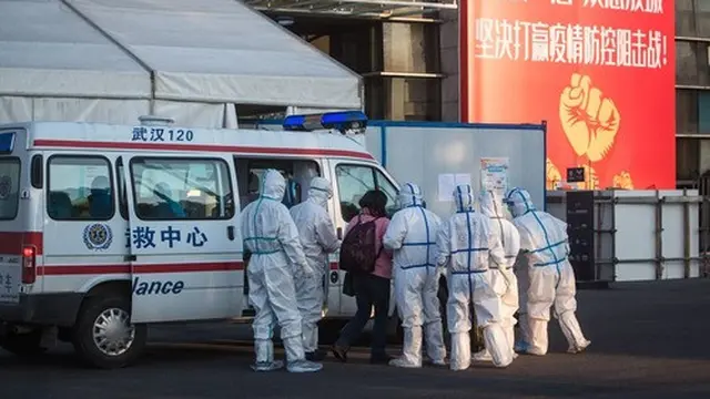 Staf medis menerima seorang pasien yang terinfeksi Virus Corona di sebuah rumah sakit darurat yang sebelumnya merupakan gedung olahraga Wuhan Sports Center di Wuhan, Provinsi Hubei, China tengah. (Xinhua/Xiao Yijiu)
