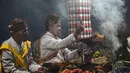 Para pemimpin komunitas melakukan ritual sebelum mendaki gunung berapi aktif Bromo untuk mempersembahkan sesaji berupa beras, buah-buahan, ternak, dan barang-barang lainnya sebagai bagian dari festival Yadnya Kasada di dekat Probolinggo, Jawa Timur, Senin 1 Juni 2026. (JUNI KRISWANTO/AFP)