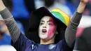 Suporter Timnas Italia mencat wajahnya dengan warna bendera nasionalnya saat menyaksikan pertandingan melawan Spanyol pada laga semifinal Euro 2020 di Stadion Wembley, Rabu (7/7/2021). (Foto:AP/Frank Augstein,Pool)