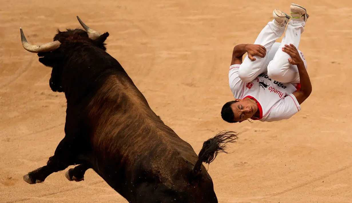 Seorang peserta melompat melewati seekor banteng dalam Festival San Fermin di Pamplona, Spanyol, (11/7/2015). (AP Photo/Andres Kudacki)