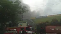 Petugas pemadam kebakaran bersama tim relawan berjibaku memadamkan api yang membakar gudang Induk RSKD Balikpapan.