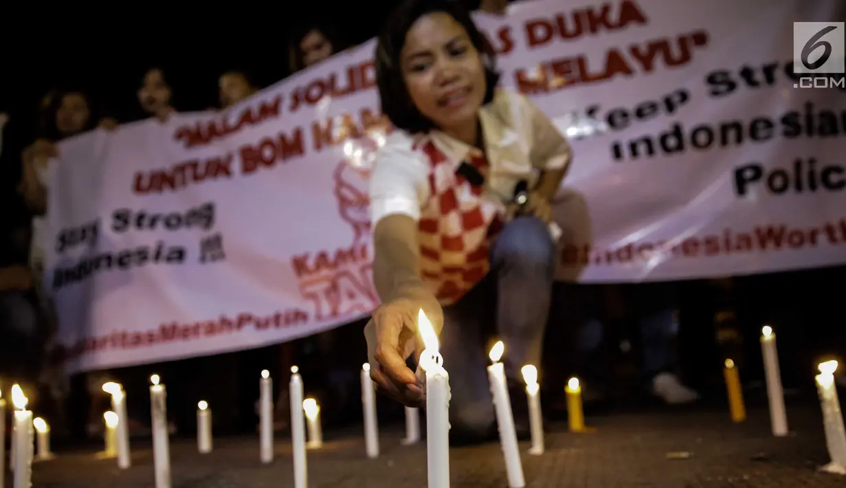 Massa dari Solidaritas Merah Putih menggelar aksi lilin dan tabur bunga di lokasi bom Terminal Kampung Melayu, Jakarta, Kamis (25/5). Aksi tersebut sebagai bentuk malam solidaritas duka untuk bom Kampung Melayu.(Liputan6.com/Faizal Fanani)