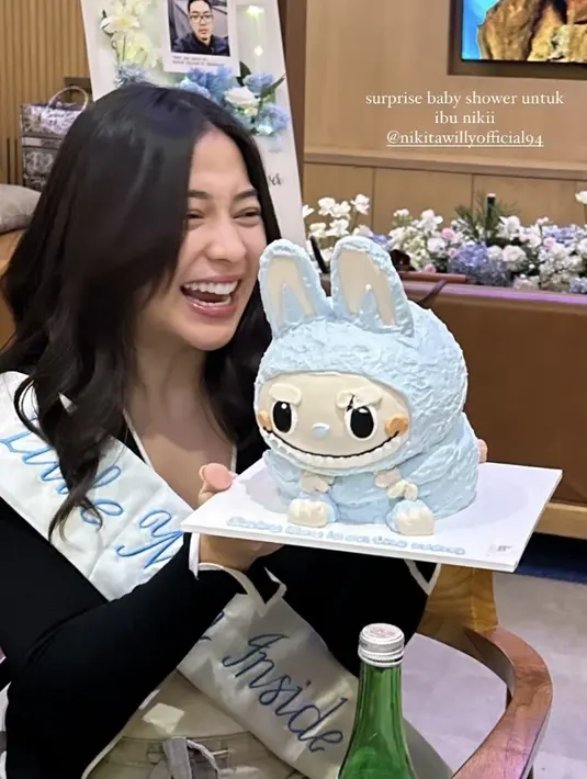 Tampak Nikita Willy pun mendapatkan sash putih dengan bordiran tulisan biru yang ia kenakan. Rambut panjang wavy dibiarkan terurai dengan poni belah duanya. [@chachathaib]