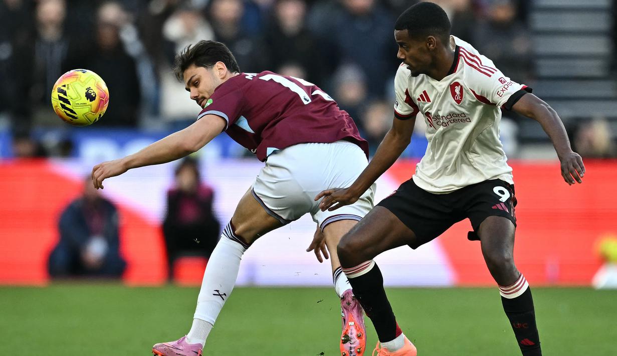 Pemain Liverpool, Alexander Isak (kanan) berebut bola dengan pemain West Ham, Konstantinos Mavropanos dalam laga Liga Inggris 2025/2026 di London Stadium, London, Inggris, Minggu (30/11/2025) waktu setempat. (AFP/Ben Stansall)