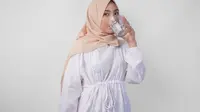 Ilustrasi seorang muslimah sedang minum air mineral. (Reezky11/DepositPhotos.com)
