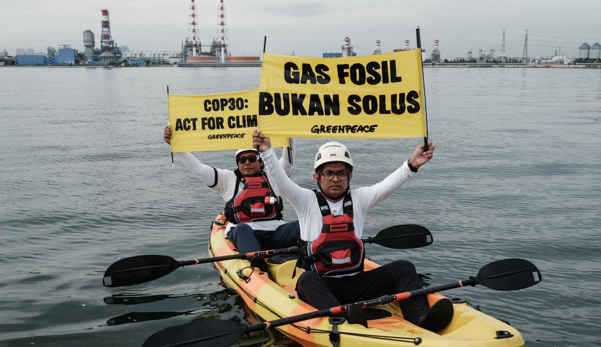 Aksi ini bertepatan dengan berlangsungnya Konferensi Perubahan Iklim PBB COP30 di Belem, Brasil. Tampak dalam foto, aktivis Greenpeace Indonesia melakukan aksi di kawasan perairan depan Pembangkit Listrik Tenaga Gas Uap (PLTGU) Muara Karang, Jakarta pada Selasa 18 November 2025. (YASUYOSHI CHIBA/AFP)