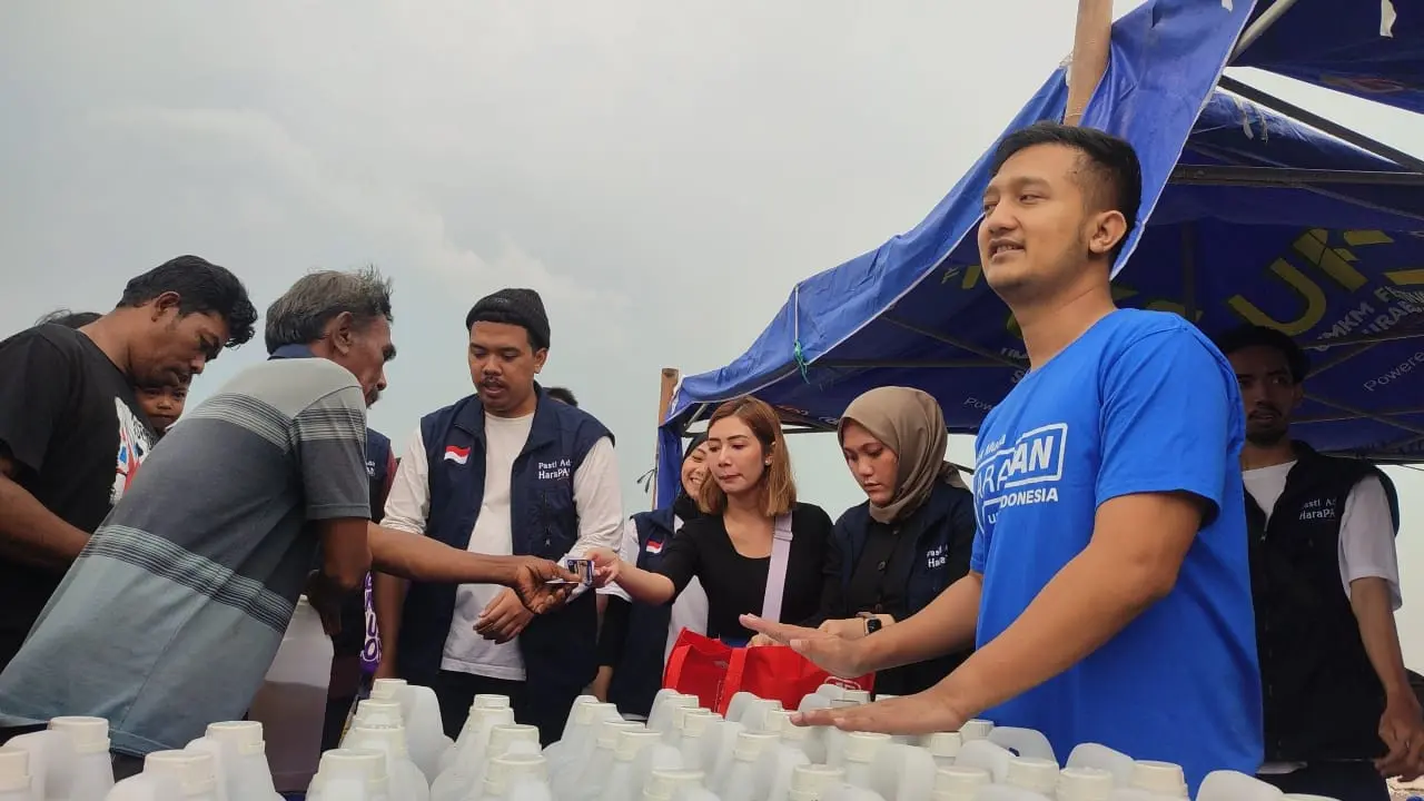 Tom Liwafa membagikan BBM untuk nelayan Surabaya. (Dian Kurniawan/Liputan6.com)