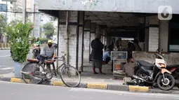 Pengojek sepeda menunggu penumpang di kawasan Pasar Asemka, Jakarta, Selasa (21/4/2020). Penghentian sementara aktivitas sebagian besar pertokoan dan perkantoran seiring pelaksanaan WFH dan PSBB berimbas pada sulitnya pengojek sepeda mencari penumpang. (Liputan6.com/Helmi Fithriansyah)