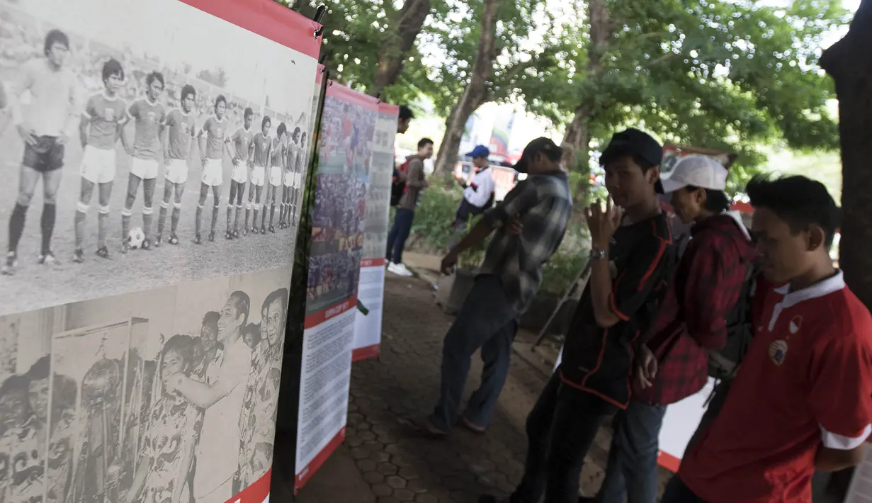 Para pengunjung bernostalgia dengan sejarah sepak bola Jakarta saat pameran foto memperingati hari jadi Persija Jakarta di Lapangan Banteng, Jakarta, Jumat (28/11/2015). (Bola.com/Vitalis Yogi Trisna)