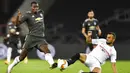 Pemain Sevilla, Joan Jordan, berebut bola dengan pemain Manchester United, Paul Pogba, pada laga semifinal Liga Europa di Stadion RheinEnergie, Senin (17/8/2020). Sevilla menang 2-1 atas Manchester United. (Marius Becker/dpa via AP)