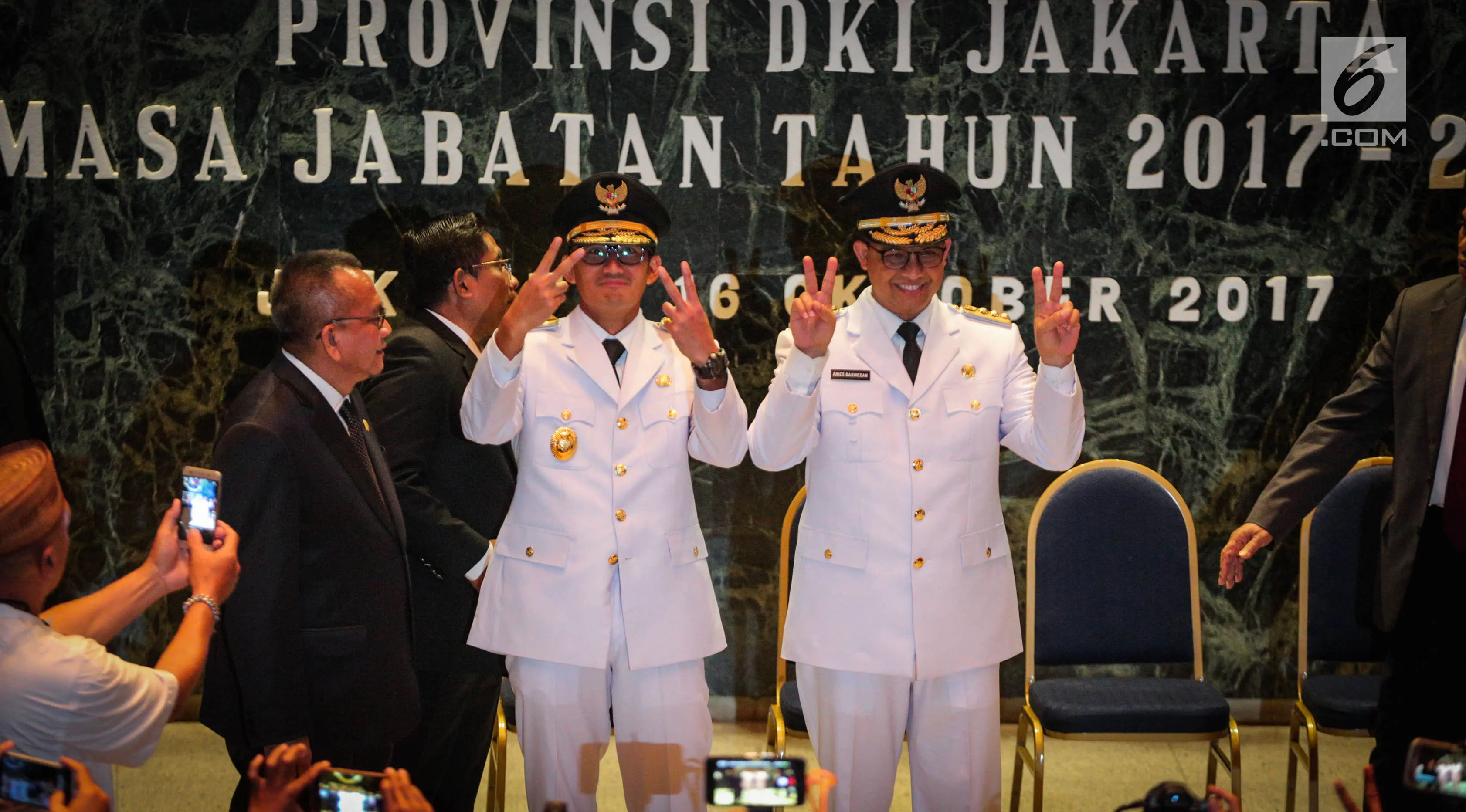 Gubernur dan Wagub DKI Jakarta, Anies Baswedan (kanan) dan Sandiaga Uno (kiri) berfoto bersama usai sertijab di Balai Kota, Jakarta, Senin (16/10). (Liputan6.com/Faizal Fanani)
