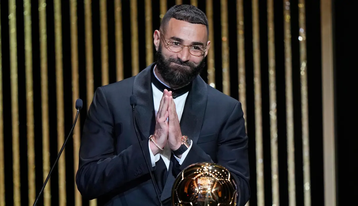 Pemain Real Madrid, Karim Benzema mengembangkan senyum saat terpilih memenangkan trofi Ballon d'Or 2022 di Theater du Chatelet, Paris, Prancis, Senin (17/10/2022). Musim 2021-2022, Karim Benzema berhasil mencetak 50 gol dan 16 assists dari 56 pertandingan di level klub dan timnas. (AP Photo/Francois Mori)