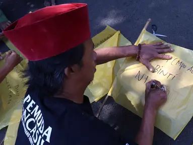 Salah satu warga membantu menuliskan nama Nina Carolina atau yang akrab dikenal dengan panggilan Mpok Alpa sesaat sebelum jenazah tiba di rumah duka, kawasan Ciganjur, Jakarta pada Jumat Jumat (15/8/2025). (KapanLagi.com/Budy Santoso)