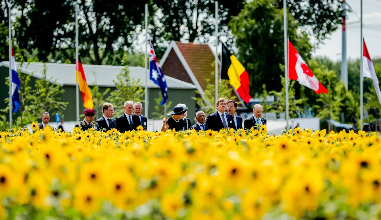 Raja Willem-Alexanderdan Ratu Maxima menghadiri pembukaan taman untuk mengenang para korban pesawat MH17 di Vijhuizen, Belanda, Senin (17/7). Taman berbentuk pita itu dikelilingi bunga matahari yang mekar setiap Juli. (Remko de Waal / Pool via AP)