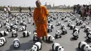 Seorang biksu Buddha berjalan diantara sejumlah patung Panda berjejer di depan Grand Palace, Bangkok , Thailand , 4 Maret 2016. Patung Panda ini merupakan pameran yang dibuat oleh seniman Perancis Paulo Grangeon. (REUTERS / Chaiwat Subprasom)
