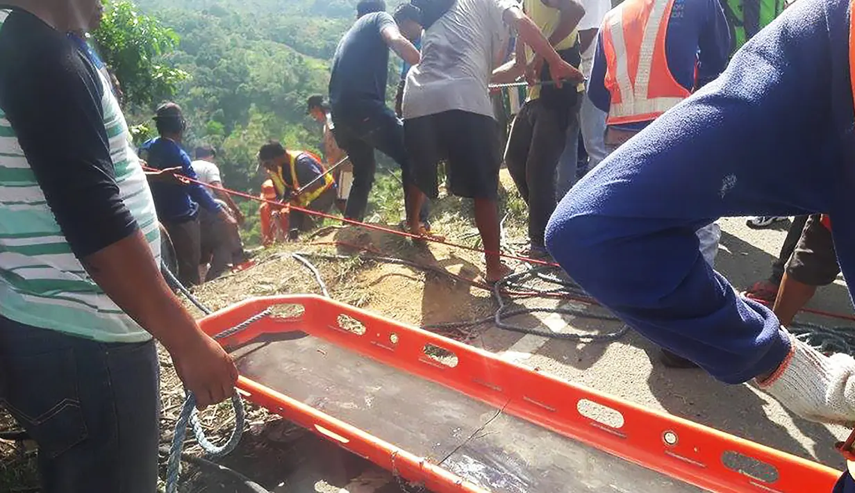 Petugas penyelamat menggunakan tandu untuk mengevakuasi penumpang bus yang terjun ke jurang di Kota Carranglan, Provinsi Nueva Ecija di Filipina Utara, Selasa (18/4). Bus terjun ke dalam jurang sedalam 24 meter di kawasan pegunungan. (Handout/MDRRMO/AFP)