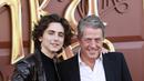 Chalamet melemparkan senyum lebarnya di samping Hugh Grant, yang memerankan Lofty si Oompa-Loompa. (JC Olivera / GETTY IMAGES NORTH AMERICA / Getty Images via AFP)