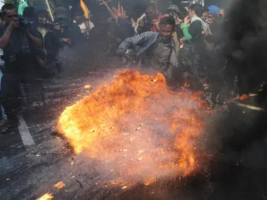 Ribuan mahasiswa dari berbagai kampus melakukan aksi peringatan Hari Kebangkitan Nasional di depan Istana Presiden, Jakarta, Rabu (20/5/2015). Dalam aksinya mereka membakar ban bekas dan menuntut agar Jokowi - JK segera turun. (Liputan6.com/Johan Tallo)