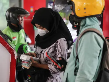 Petugas Stasiun Pengisian Bahan Bakar Umum (SPBU) mengenakan pakaian batik saat melayani konsumen di SPBU MT Haryono, Jakarta, Senin (2/10/2023). (Liputan6.com/Faizal Fanani)