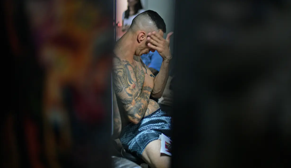 Seorang pria bereaksi saat tubuhnya ditato dalam dalam acara Tattoo Week tahunan di Rio de Janeiro, Brasil (12/1). Ajang perhelatan seniman dan penggemar tato ini diadakan setiap tahunnya di Brasil. (AFP Photo/Mauro Pimentel)