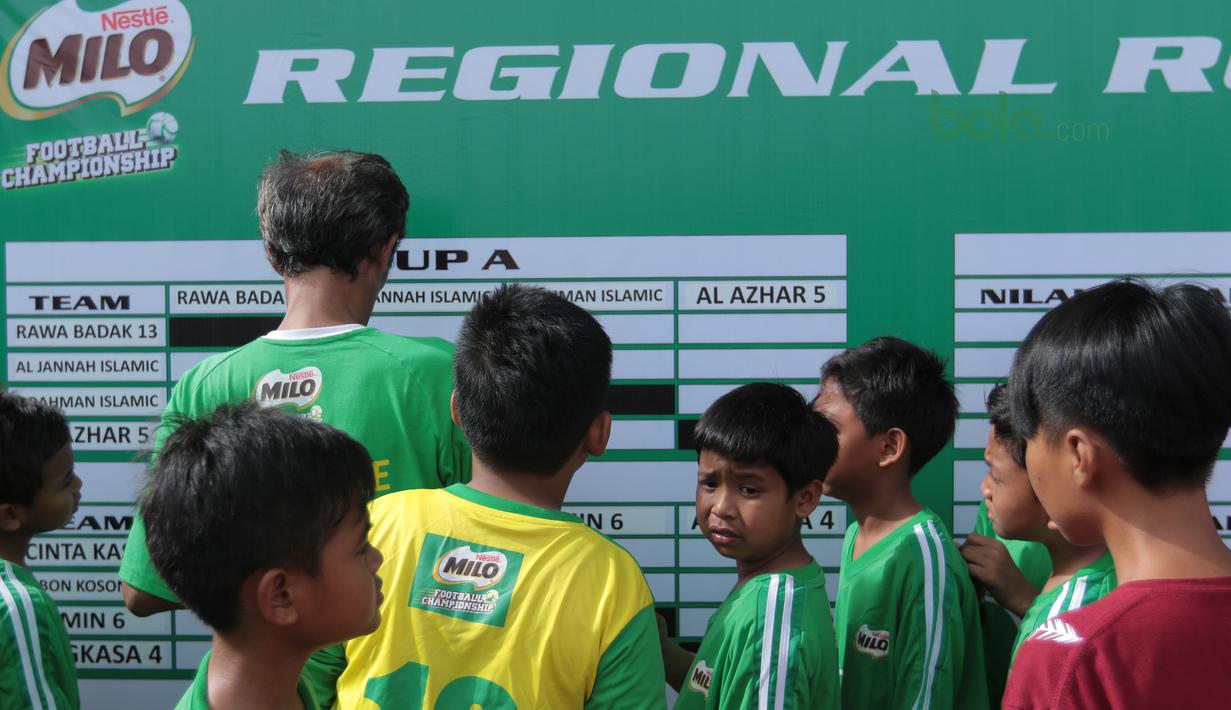 Anak-anak melihat hasil pertandingan sebelum berlaga pada ajang MILO Football Championship 2018 di Lapangan Panahan GBK, Jakarta, (24/3/2018). Sekitar 128 Sekolah Dasar di Jakarta ikut ambil bagian pada ajang tersebut. (Bola.com/Nick Hanoatubun)