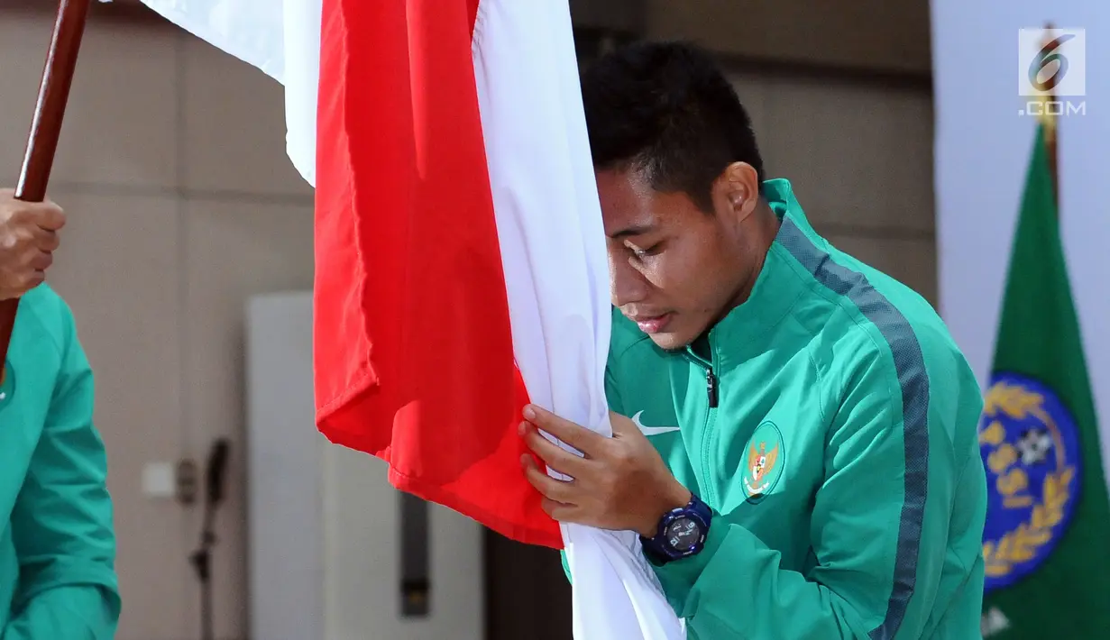 Pemain Timnas U-22, Evan Dimas Darmono mencium bendera Merah Putih saat pelepasan di Makostrad, Jakarta, Kamis (10/8). Ketua Umum PSSI, Edy Rahmayadi resmi melepas Timnas U-22 dan Futsal berlaga di SEA Games 2017. (Liputan6.com/Helmi Fithriansyah)