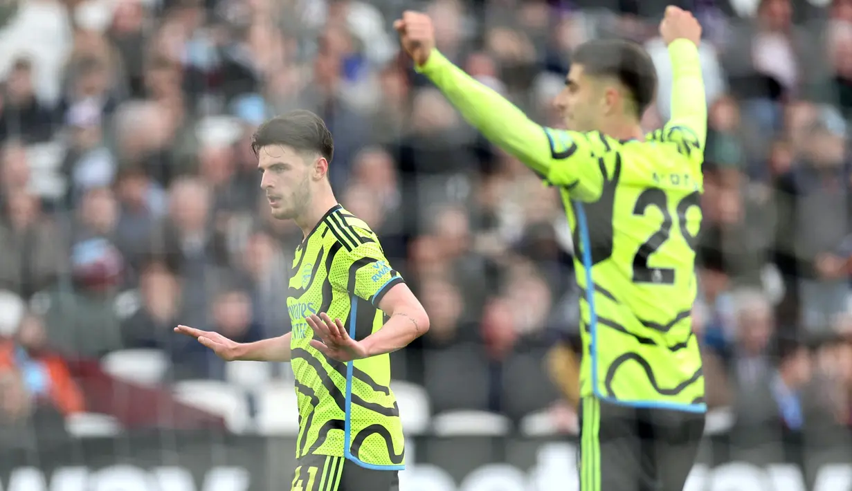 Pemain Arsenal, Declan Rice, menahan diri untuk tidak berselebrasi setelah mencetak gol ke gawang West Ham United dalam duel pekan ke-24 Premier League 2023/2024 di Stadion London, Minggu (11/2/2024). (AFP/Adrian Dennis)