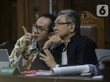 Terdakwa kasus TTPU dan korupsi pengadaan alat kesehatan di Pemprov Banten dan Pemkot Tangerang Selatan Tubagus Chaeri Wardana alias Wawan (kiri) berbincang dengan kuasa hukum saat menjalani sidang lanjutan di Pengadilan Tipikor Jakarta, Senin (20/1/2020). (Liputan6.com/Faizal Fanani)