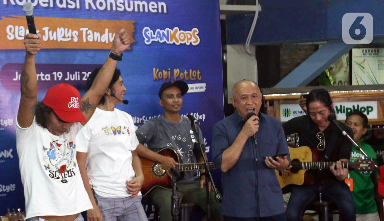 Grup band Slank bernyanyi bersama Menteri Koperasi dan UKM Teten Masduki (kanan depan) usai peluncuran Slankops di Basecamp Slank, Jakarta, Selasa (19/7/2022). Slank bersama Menteri Koperasi dan UKM Teten Masduki dan Menteri BUMN Erick Thohir bernyanyi bersama membawakan lagu 'Ku Tak Bisa' dan 'Balikin'. (Liputan6.com/Herman Zakharia)