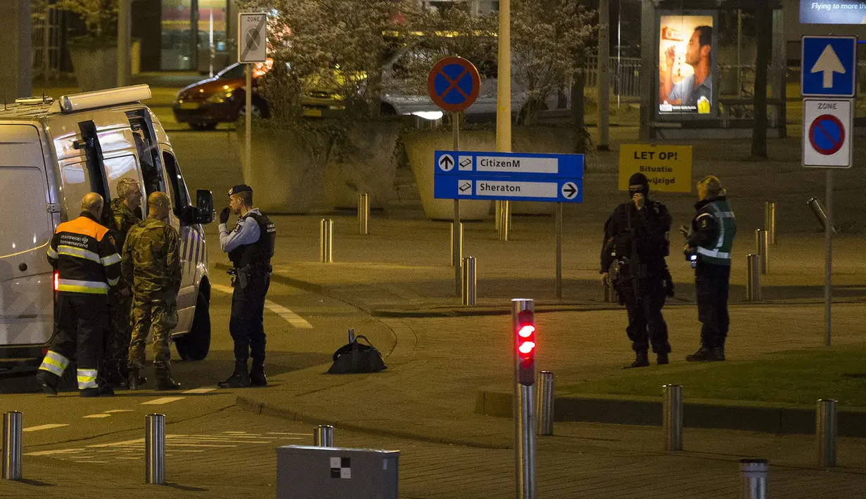 Pasukan bersenjata melakukan evakuasi di Bandara Schiphol, Amsterdam, Belanda, Selasa (12/4), sesaat setelah alarm peringatan keamanan berbunyi. Selain mengevakuasi warga, aparat juga  menangkap satu orang dalam kejadian itu. (Michel van Bergen/ANP/AFP)
