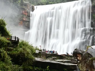 Sejumlah wisatawan mengamati air terjun Chishui di Kota Zunyi, Provinsi Guizhou, China barat daya (7/10/2020). Terkenal karena kekayaan sejarah dan sumber daya alamnya, Kota Zunyi menarik banyak wisatawan selama libur Hari Nasional dan Festival Pertengahan Musim Gugur. (Xinhua/Yang Wenbin)