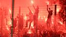 Para suporter PSG menyalakan flare setelah berakhirnya laga pekan ke-37 Liga Prancis 2022/2023 menghadapi Strasbourg di Stade de la Meinau, Strasbourg, Prancis (27/5/2023). Bermain imbang 1-1, PSG memastikan merebut gelar juara Liga Prancis 2022/2023. (AFP/Patrick Hertzog)