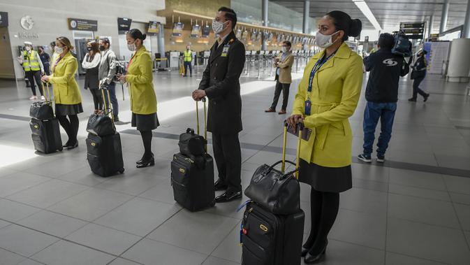 Pramugari mengenakan masker selama presentasi sistem biosekuriti COVID-19, di Bandara Internasional El Dorado, Bogota, Kolombia, Senin (31/8/2020). Presiden Kolombia Ivan Duque mengizinkan lebih banyak penerbangan domestik mulai September. (Juan BARRETO/AFP)