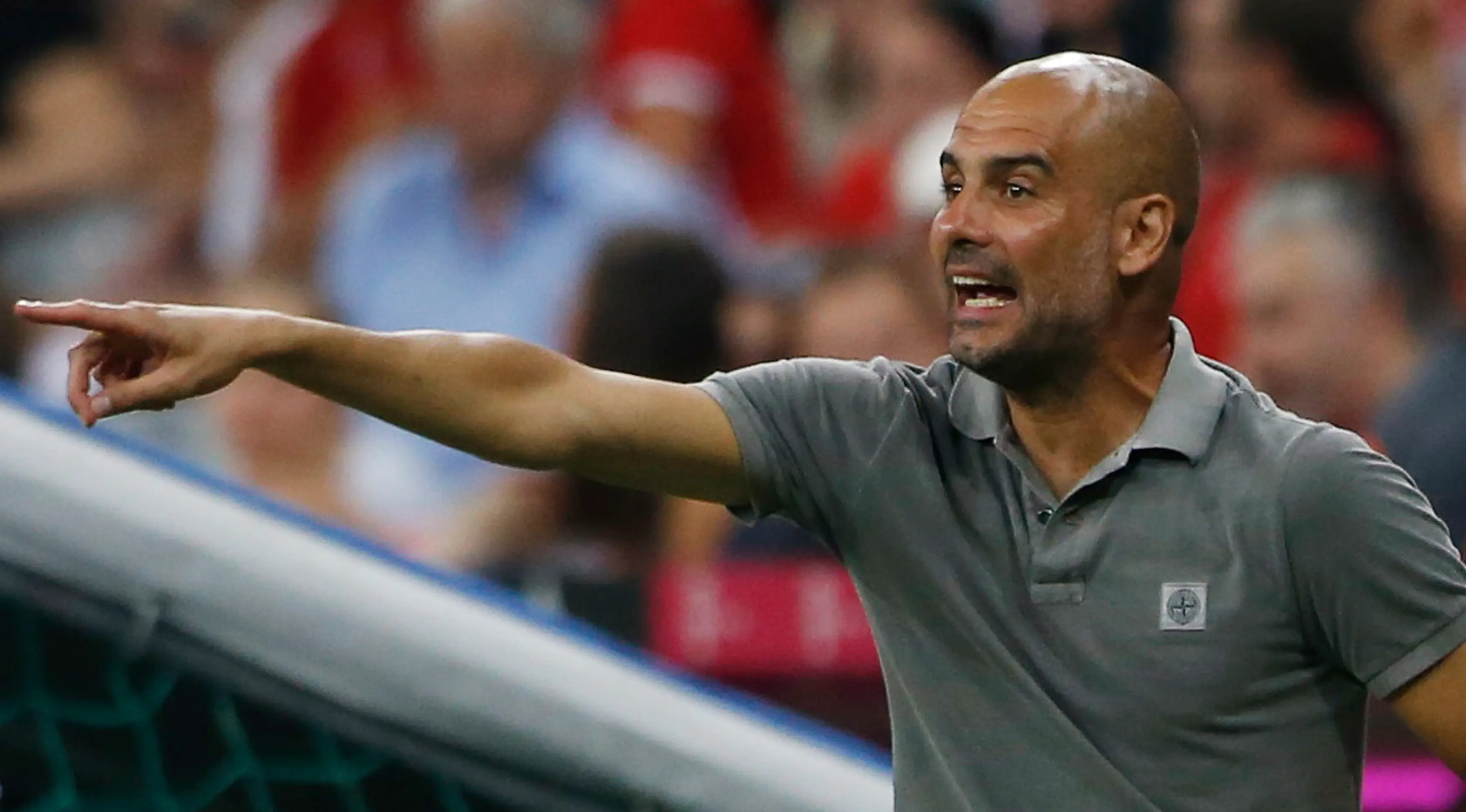 Pep Guardiola mengintruksikan pemainnya saat bertanding melawan Bayern Muenchen di laga pramusim di Allianz Arena, Muenchen (21/7). Muenchen sendiri merupakan mantan klub yang pernah ditangani Guardiola selama tiga musim. (Reuters/Michaela Rehle)