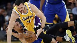 Pemain Los Angeles Lakers, Larry Nance Jr. merebut bola dari pemain Golden State Warriors, Stephen Curry (bawah) pada laga NBA basketball game di Los Angeles, (4/11/2016).  (AP /Alex Gallardo)