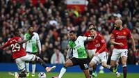 Pemain Liverpool Cody Gakpo (tengah) dibayangi bek Manchester United Aaron Wan-Bissaka (kiri) dalam laga lanjutan Liga Inggris 2023/2024 antara MU vs Liverpool di Stadion Old Trafford, Minggu (7/4/2024) malam WIB. Setan Merah gagal memutus tren kemenangannya di laga kali ini setelah ditahan imbang 2-2 oleh The Reds.&nbsp;(Paul ELLIS / AFP)