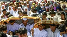 Sejumlah pelajar dan warga melindungi diri dari terik matahari saat mengikuti salat Istisqa untuk memohon turunnya hujan di tengah kekeringan berkepanjangan akibat fenomena El Niño di Malang, Jawa Timur, Kamis (22/10/2026). (Hayu Yudha/AFP)