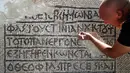 Arkeolog meneliti lantai mosaik berusia 1.500 tahun di Museum Rockefeller, Yerusalem, Rabu (23/8). Prasasti bertuliskan aksara dan bahasa Yunani kuno ditemukan selama pengerjaan pemasangan kabel komunikasi di Kota Tua Yerusalem. (AHMAD GHARABLI/AFP)