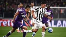 Pemain Juventus Paulo Dybala melewati pemain Fiorentina Lucas Martinez Quarta (kiri) pada pertandingan leg kedua semifinal Coppa Italia di Stadion Juventus, Turin, Italia, 20 April 2022. Juventus menang 2-0. (Marco BERTORELLO/AFP)