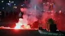 Aparat kepolisian Serbia bentrok dengan pengunjuk rasa di dekat gedung parlemen di Beograd, Selasa (7/7/2020). Ribuan pengunjuk rasa marah setelah pemerintah mengeluarkan keputusan untuk memberlakukan kembali jam malam akibat melonjaknya kasus Covid-19. (AP/Marko Drobnjakovic)
