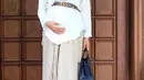 Agar terlihat lebih stylish, kamu bisa tambahkan aksesori berupa ikat pinggang saat memadukan kemeja dengan rok pleats seperti Aurel Hermansyah kala hamil ini. (Instagram/aurelie.hermansyah).