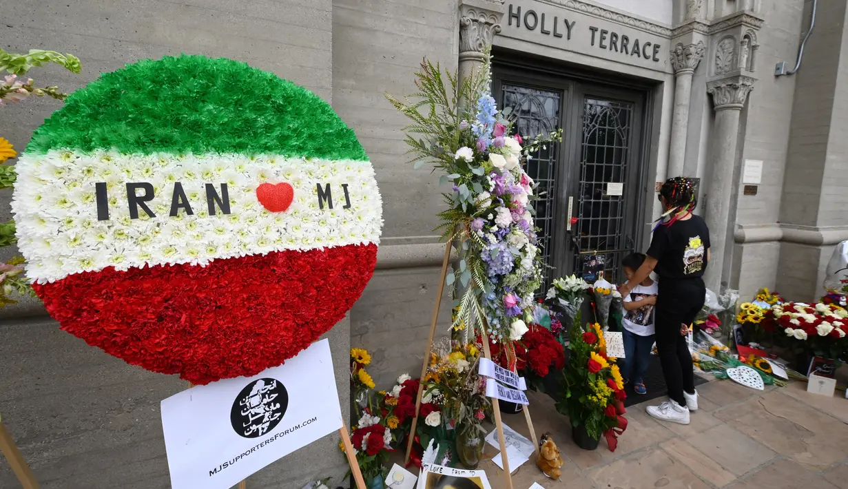 Penggemar berkumpul di luar tempat peristirahatan terakhir Michael Jackson di mausoleum Holly di Terrace Forest Lawn Cemetery, California, Selasa (25/6/2019). Tepat pada hari ini sepuluh tahun yang lalu berita kematian King of Pop Michael Jackson sempat mengguncang dunia. (Robyn Beck/AFP)
