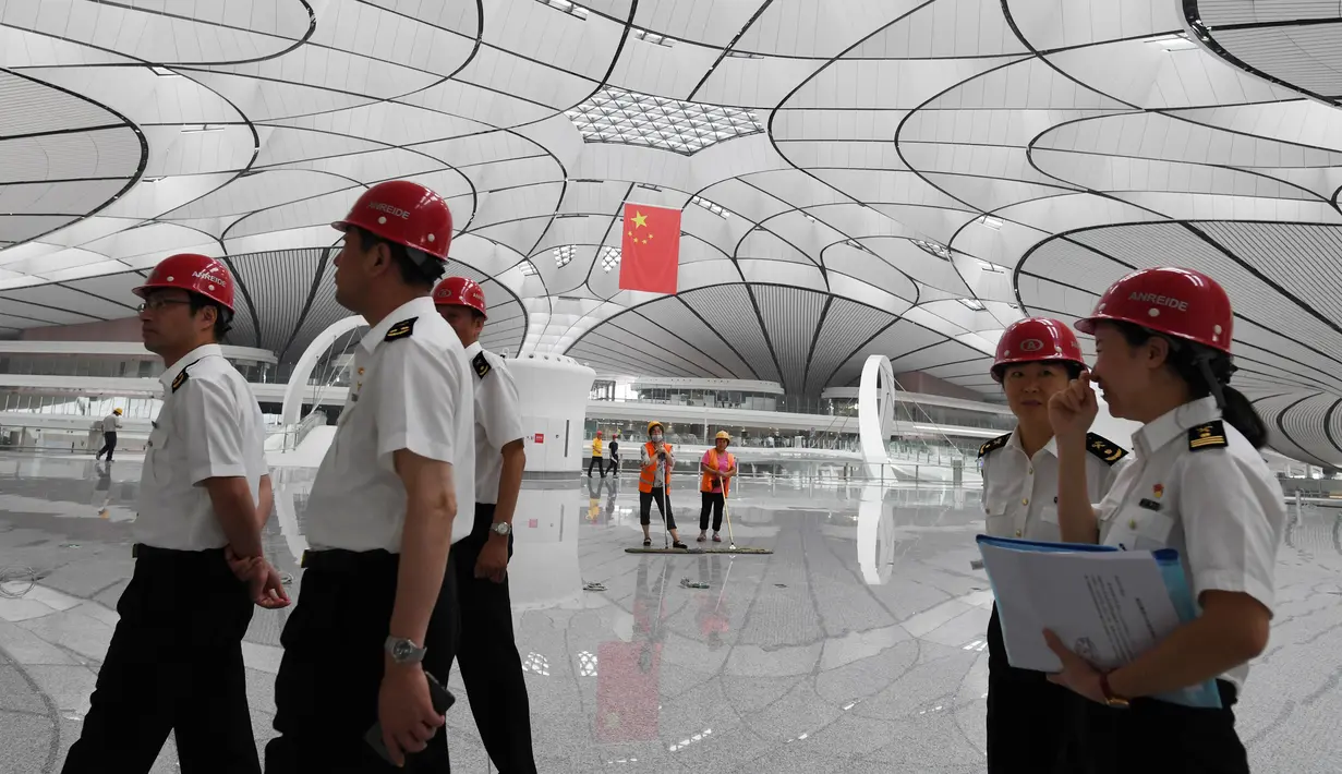 Pejabat pabean berkeliling Terminal Bandara Internasional Daxing Beijing, China, Selasa (9/7/2019). Bandara Internasional Daxing Beijing menerapkan desain ruang terbuka. (GREG BAKER/AFP)