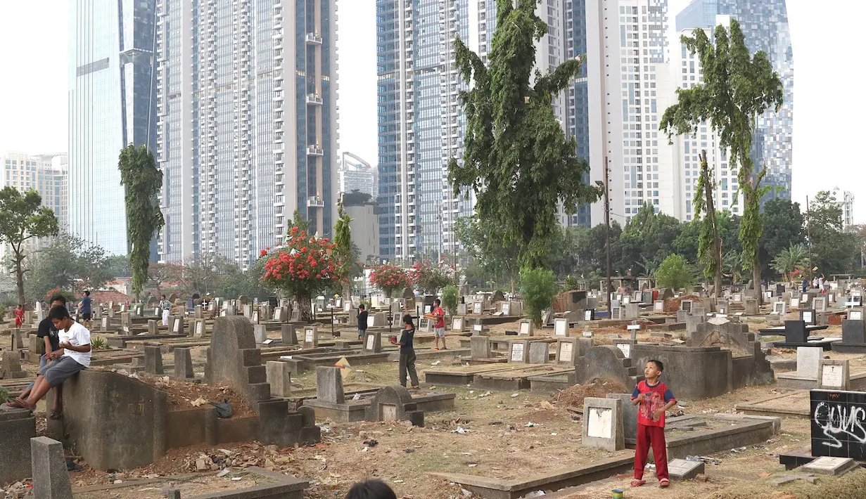Anak-anak bermain layang-layang di TPU Menteng Pulo, Jakarta, Kamis (18/10). Padatnya pemukiman penduduk serta gedung bertingkat di kawasan tersebut menyebabkan anak-anak terpaksa bermain di tempat yang tidak semestinya. (Liputan6.com/Immanuel Antonius)