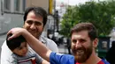 Pemuda Iran, Reza Parastesh yang berwajah mirip bintang Barcelona, Lionel Messi menyapa pejalan kaki di sebuah jalan di Teheran, Senin (8/5). Selain laris diwawancarai media, Parastesh juga kini telah meneken kontrak sebagai foto model. (ATTA KENARE/AFP)
