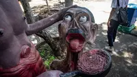 Patung-patung menggambarkan nasib orang-orang yang melakukan perbuatan buruk di sebuah taman yang menggambarkan neraka versi Buddha di kuil Wat Saeng Suk di provinsi pesisir Thailand, Chonburi (9/7/2020). (AFP/Lillian Suwanrumpha)